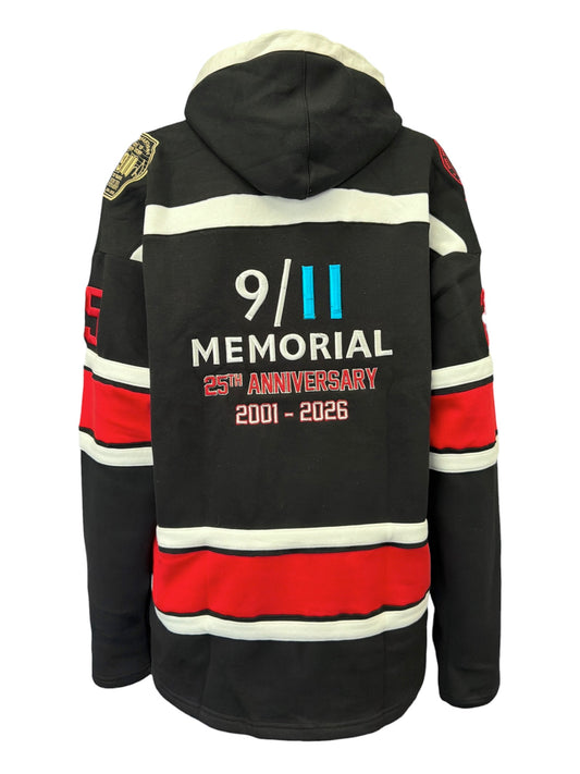 Black hockey-style hooded sweatshirt shown from the back, featuring white and red horizontal stripes and a large memorial anniversary print reading '9/11 Memorial 25th Anniversary 2001-2026' on the back.