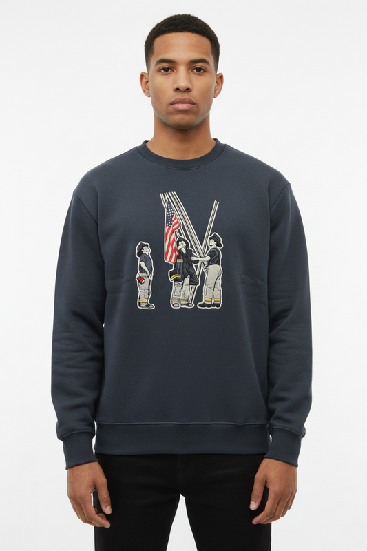 Man wearing a dark grey crewneck sweatshirt with a graphic of three firefighters raising an American flag