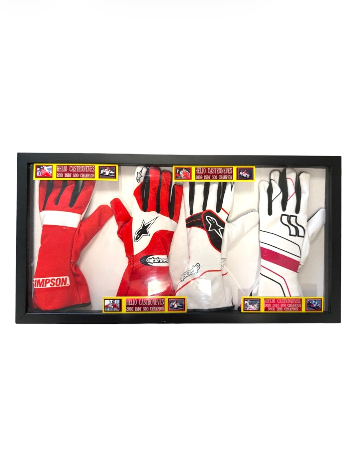 Framed display case containing four racing gloves worn by Helio Castroneves with commemorative plaques