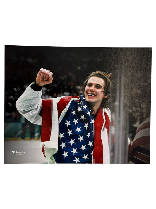 Photo of Hockey player Jack Hughes wearing a United States flag draped over his shoulders with fist raised