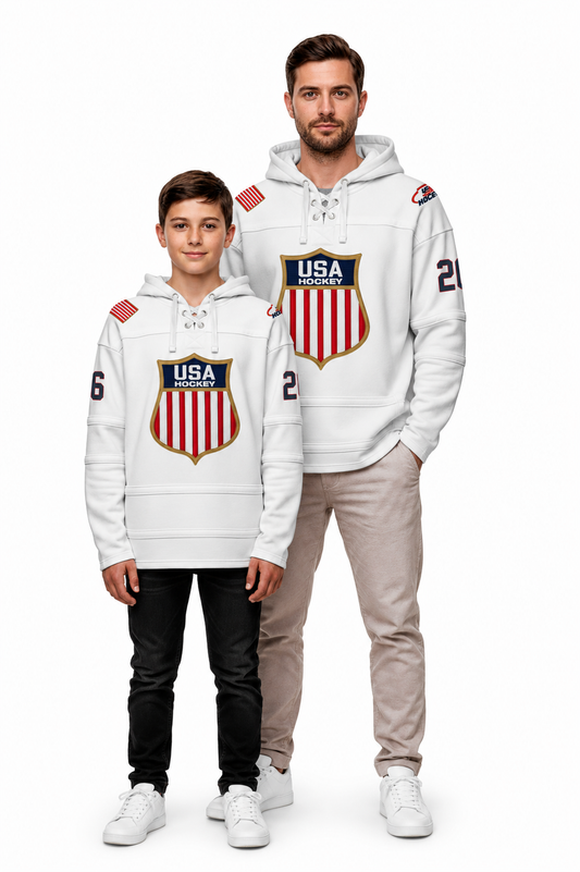 A man and a boy modeling matching white hoodies with a red, white, and blue USA Hockey shield logo on the chest, set against a plain white background.
