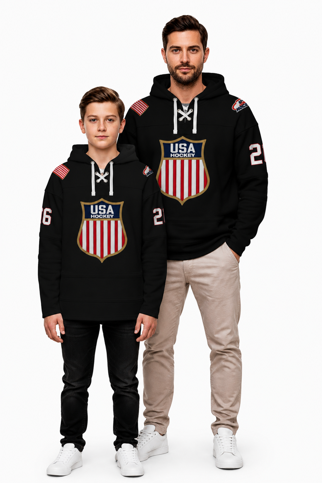 A man and a boy modeling matching black hoodies with a USA shield graphic on the front, white drawstrings, and sleeve numbers, photographed against a plain white studio background.
