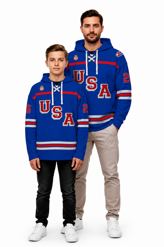A man and a boy modeling matching blue hoodies with a USA hockey theme, featuring 'USA' in red and white, white lace-up hood details, and red and white stripes on the sleeves and hem, against a plain white background.