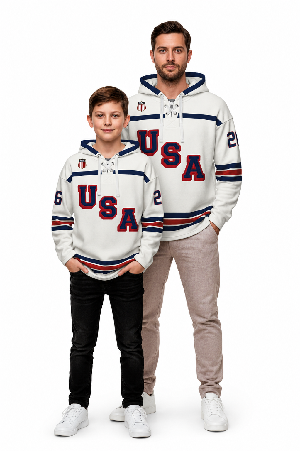 A man and a boy modeling matching white USA hockey-themed hoodies against a plain white background. The hoodies feature 'USA' in red and navy lettering, navy and red striped sleeves, and small shield logos on the chest.