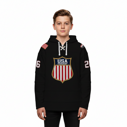 Boy wearing a black USA Hockey hoodie with lace up collar and shield logo