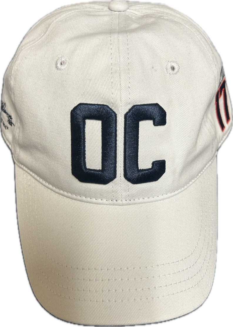 Off white baseball cap with navy blue OC embroidery on the front