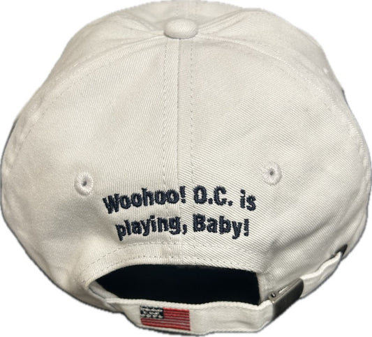 White baseball cap with embroidered text Woohoo OC is playing Baby and a small American flag on the back strap